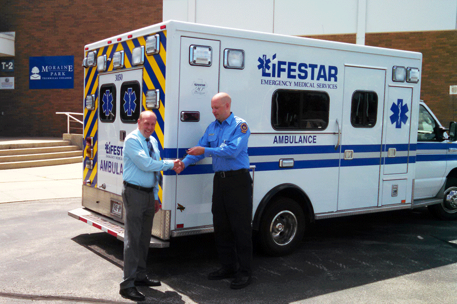 Moraine Park Dean of Health Service with a paramedic standing by an ambulance