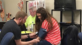 Moraine Park medical assistant student taking blood pressure of another student