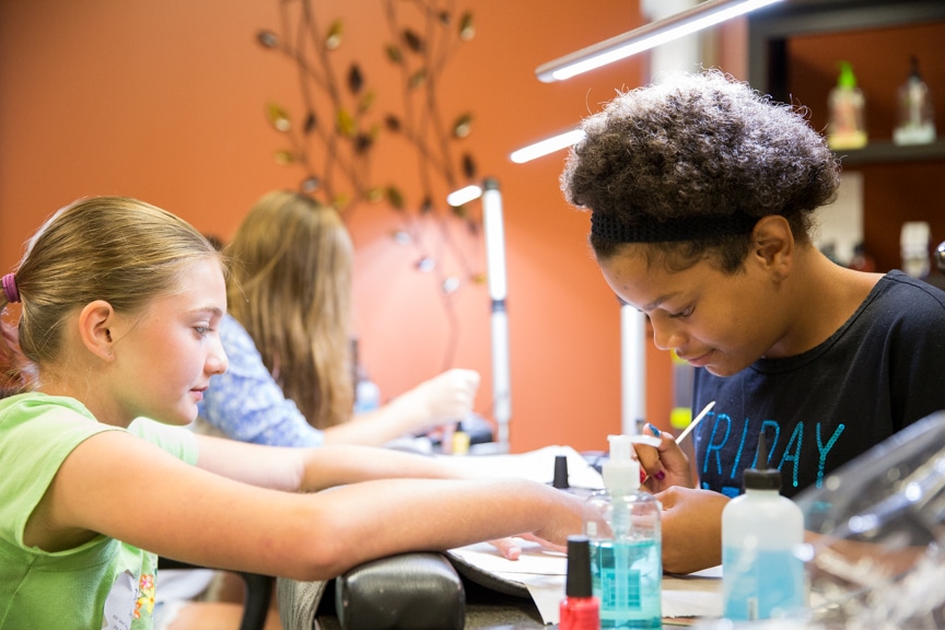 Young girls getting manicures at Tech Knowledge College event