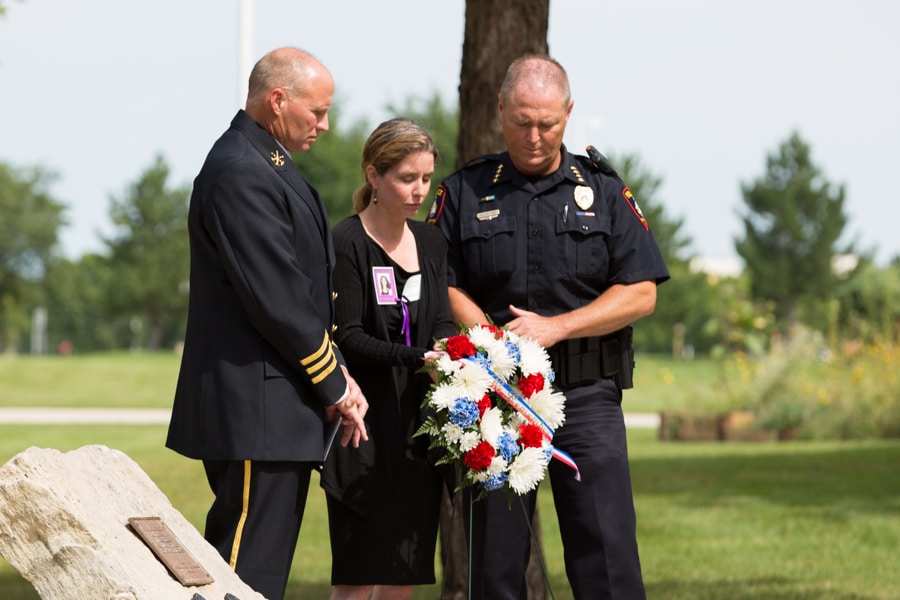 Two officers and female placing wreath at 9-11 Memorial Rededication