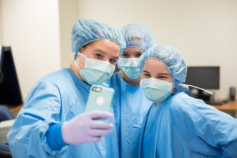 middle school students take selfie in surgical gown and masks