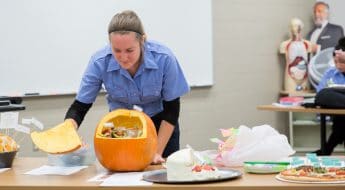 female student by pumpkin with human cell labels and descriptions