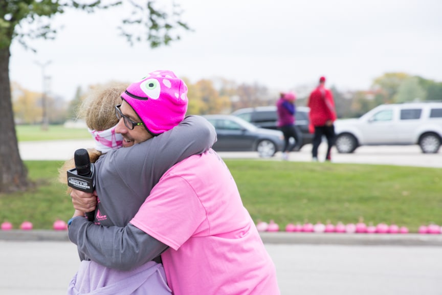 instructor hugs woman at pink pumpkin walk