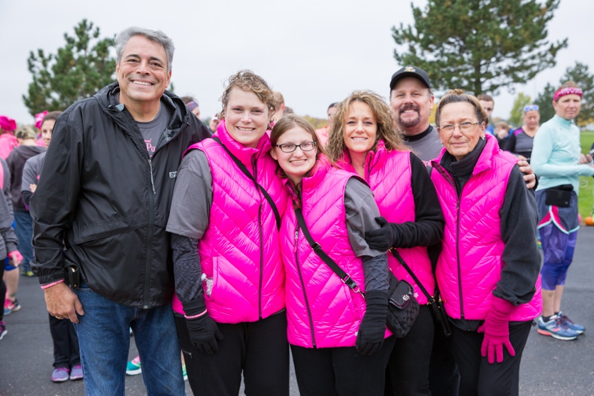 group of people wearing pink pose for picture