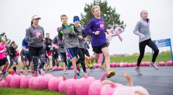 people run next to row of pink pumpkins at moraine park