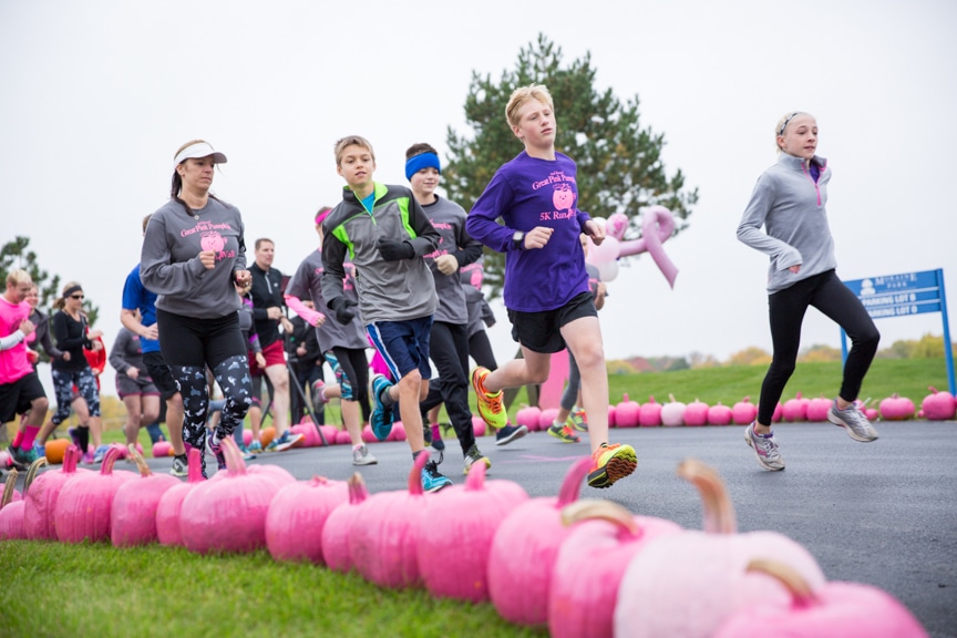 people run next to row of pink pumpkins at moraine park