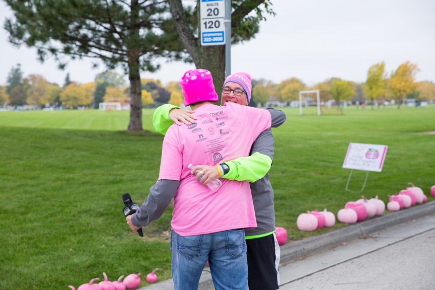 two people hug during pink pumpkin walk