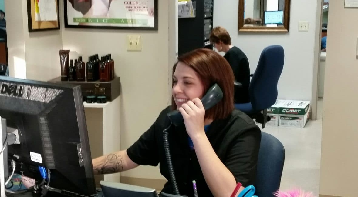 Cosmetology student booking an appointment by phone