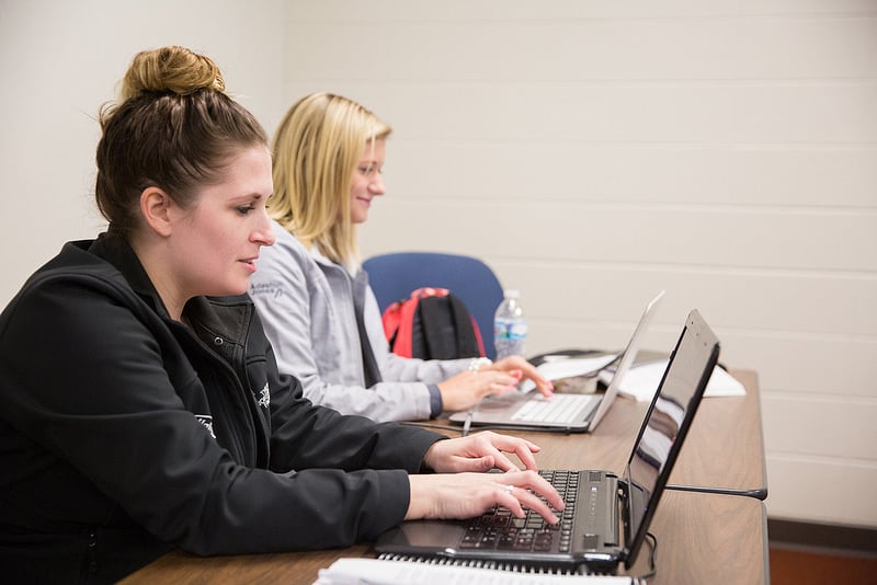 female students work at computers in human resources classroom