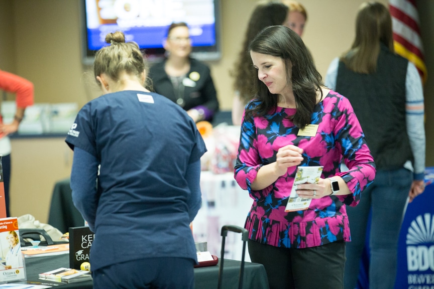 exhibitor approaches student at mptc healthcare career fair