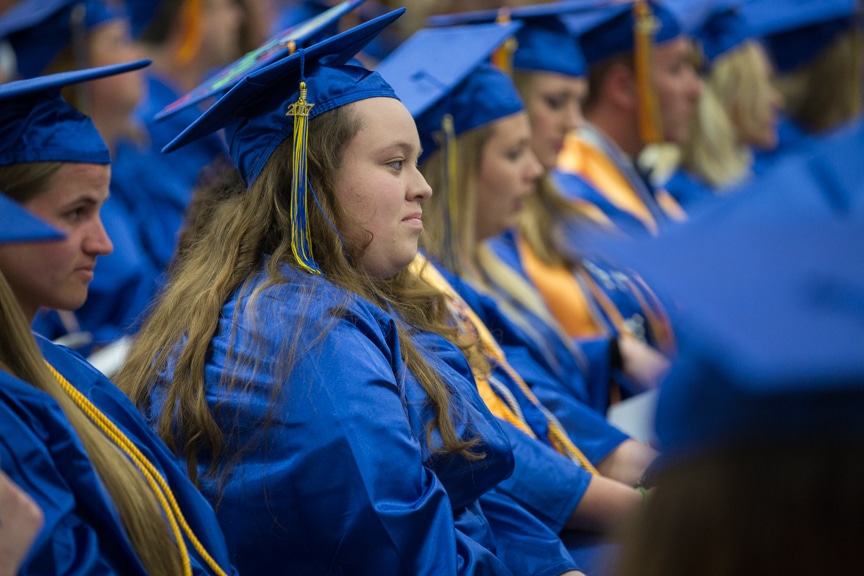 Female student listens to speech at Gradutes sit at Moraine Park commencement ceremony