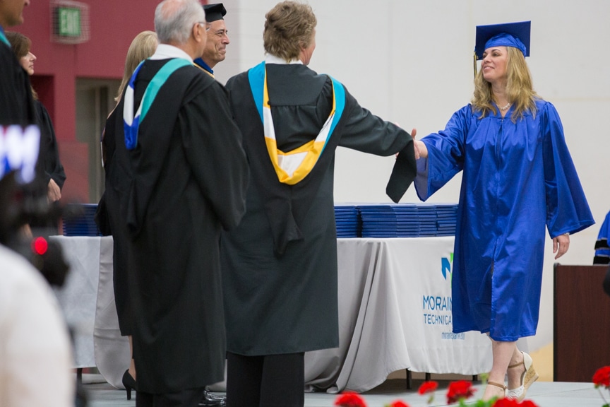 Female graduate shakes President Bonnie Baerwald hand