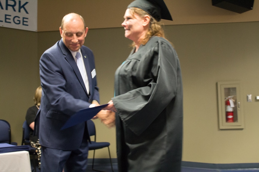 Female graduate recieves diploma at GED-HSED Gradudation Ceremony