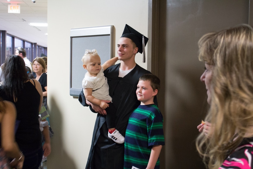 Children pose for photo with male graduate