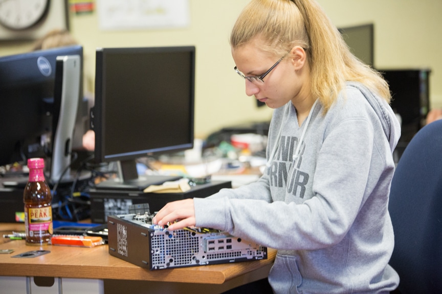 Girl works on assembling PC computer tower