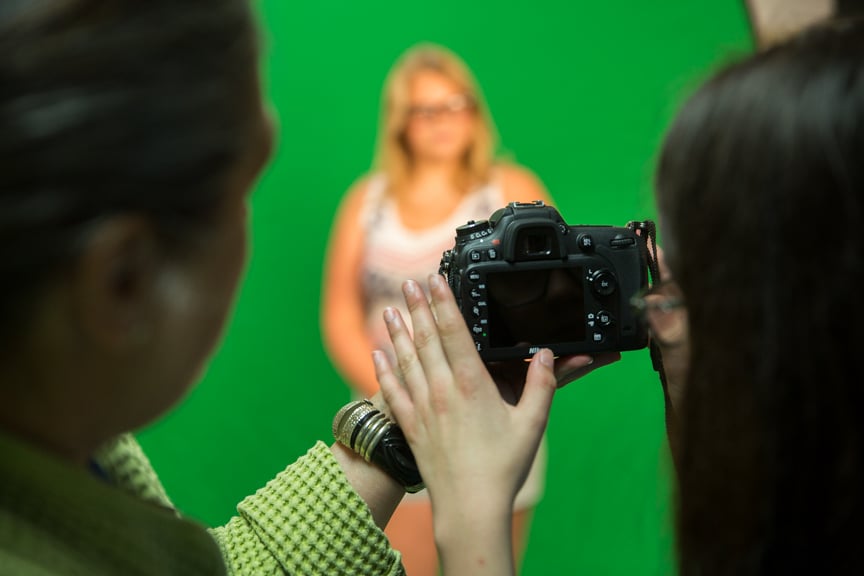 Girl takes photo of another student in front of green screen during Moraine Park summer camp