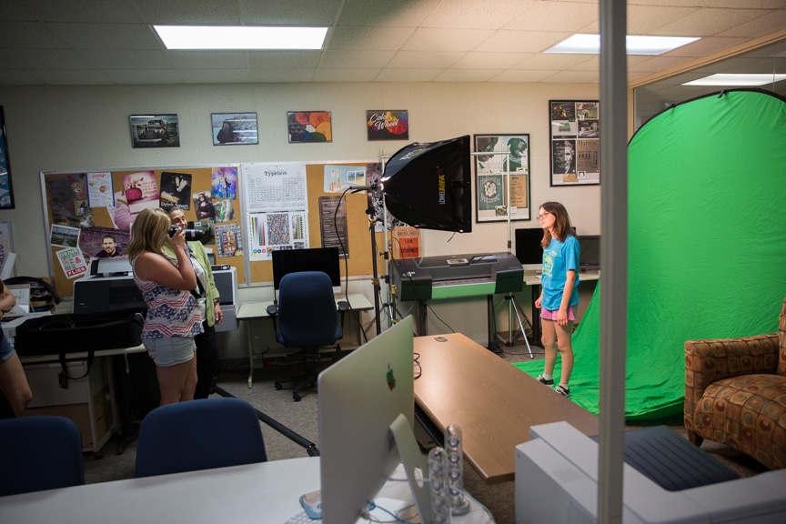 Girl photographs fellow student in front of green screen during Moraine Park summer camp activity