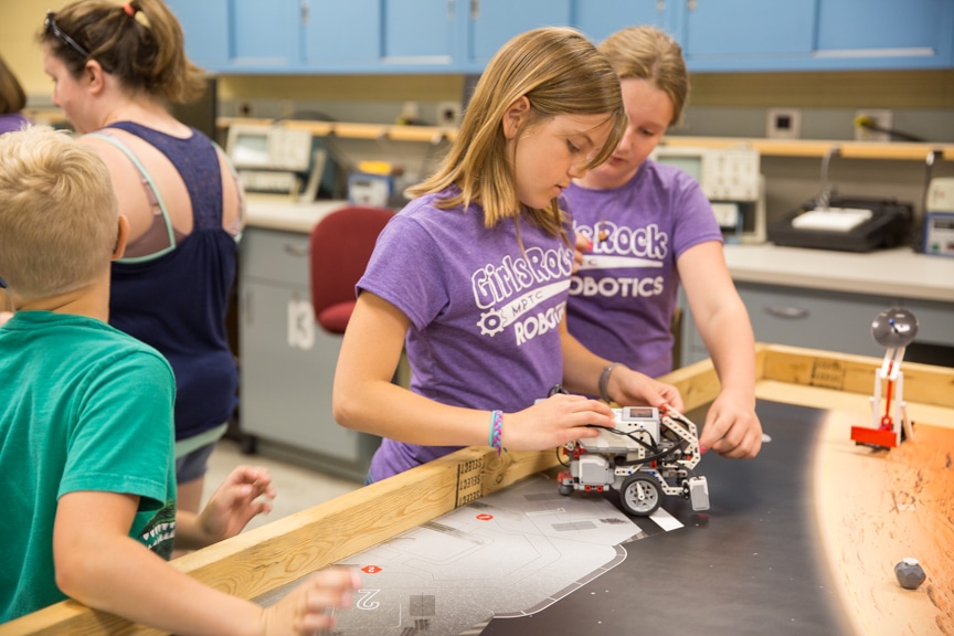 Two girls ready lego robot for demonstration at Moraine Park summer camp