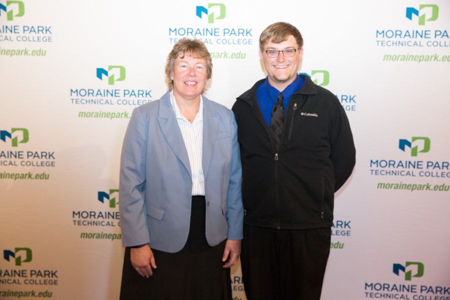 Moraine Park president Bonnie Baerwald standing with male student award banquet
