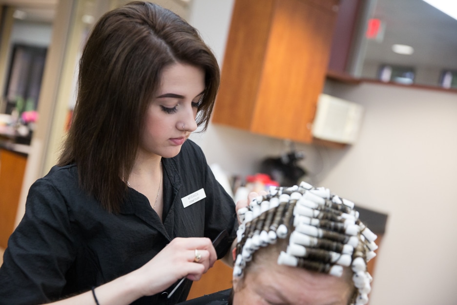 Moraine Park cosmetology student works on hairstyle in salon