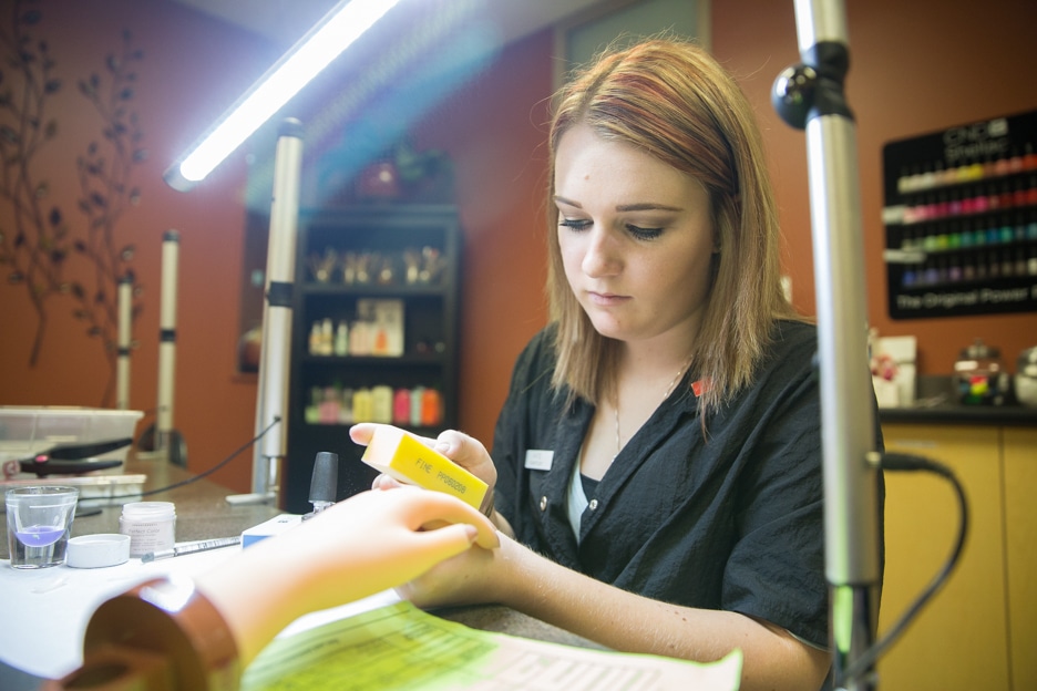 Female cosmetology student practices at a manicure station in Moraine Park salon