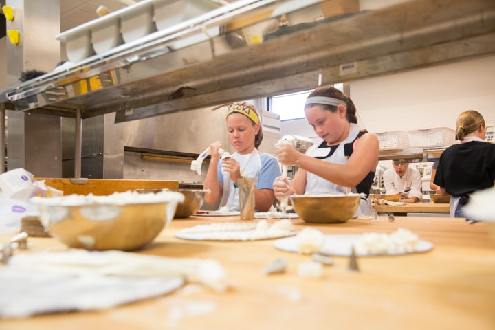 Two girls work on icing techniques during Moraine Park Tech Knowledge College culinary activity