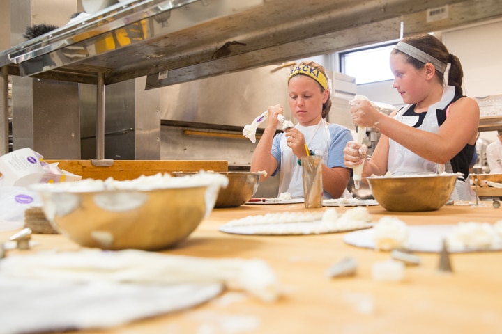 Two girls work on icing techniques during Moraine Park Tech Knowledge College culinary activity
