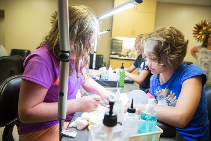 Girls learn manicure techniques during cosmetology activity at Moraine Park summer camp