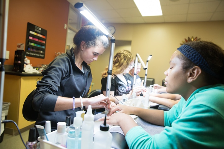 Girls practice manicure techniques during cosmetology activity at Moraine Park summer camp