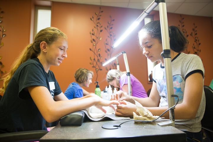 Girls practice manicure techniques during cosmetology activity at Moraine Park summer camp