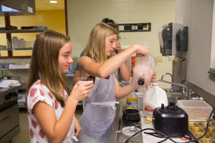 Girl pours smoothie from blender in Moraine Park kitchen at TKC