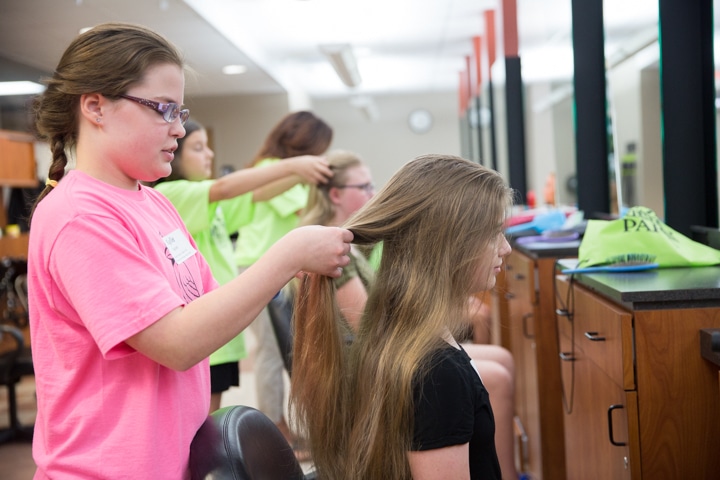 Girls style hair during Moraine Park Tech Knowledge College