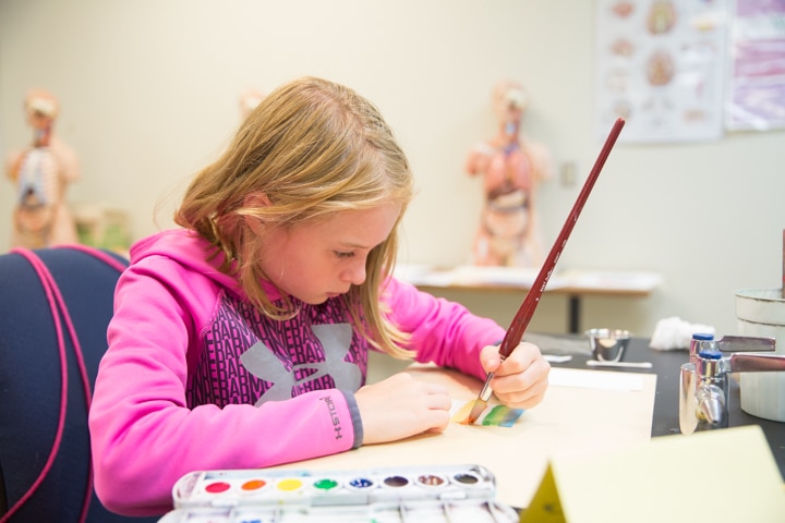 Girl works on painting activity during Moraine Park Tech Knowledge College