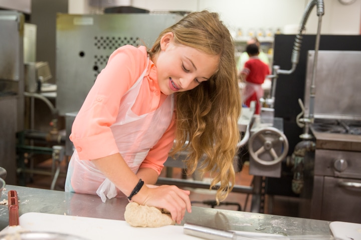 Girl works with dough in Moraine Park culinary activity at TKC