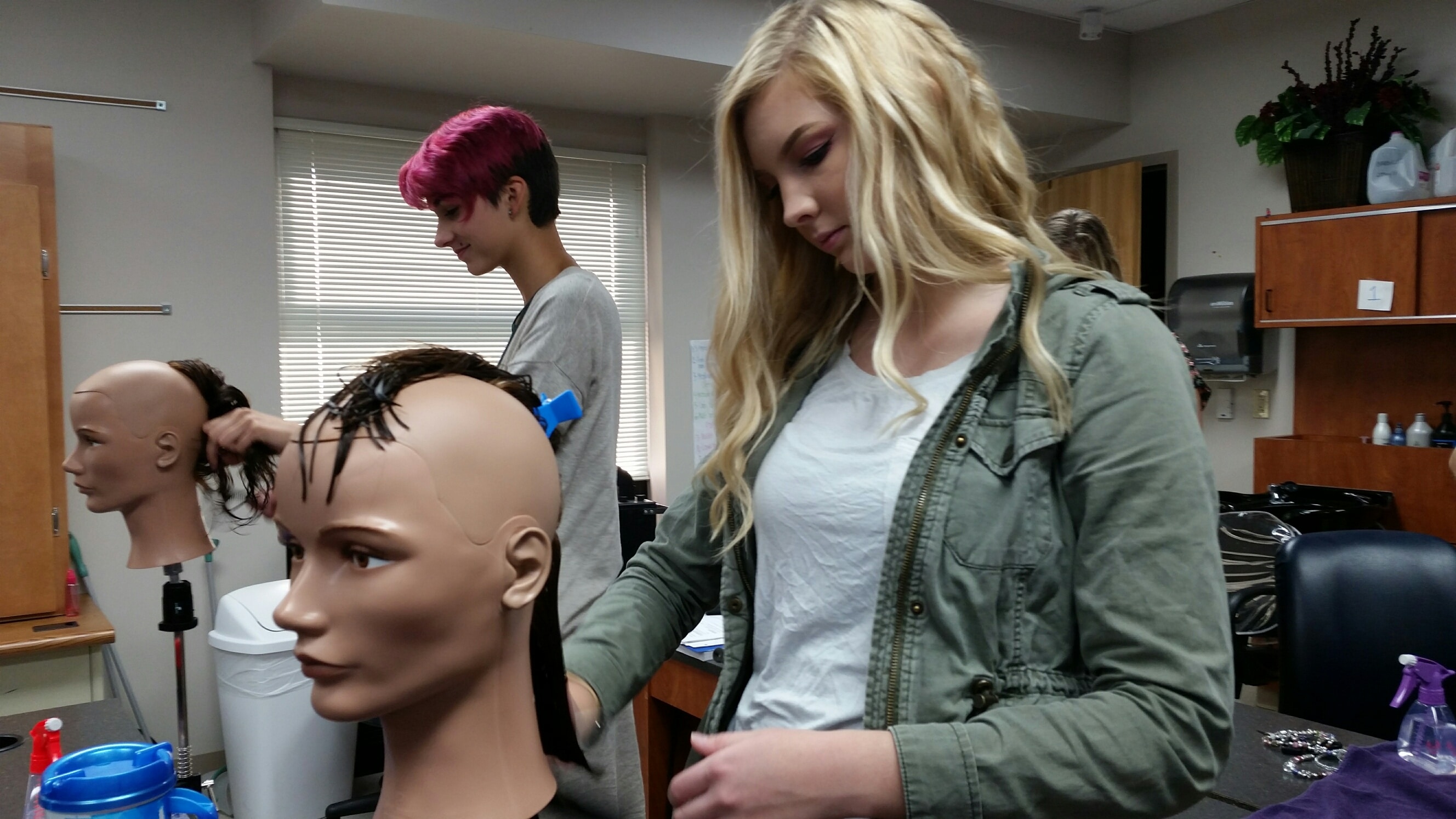 students working on mannequins in cosmetology lab at moraine park 