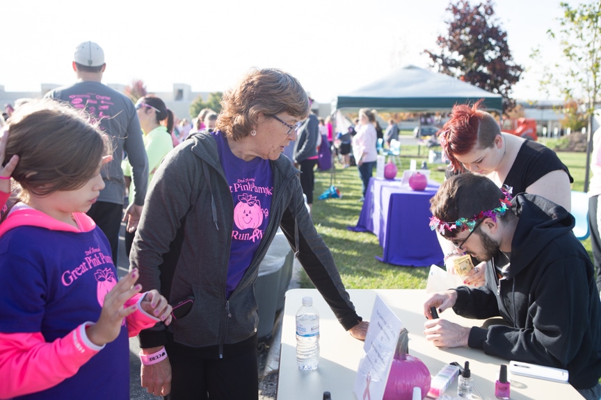 woman gets her nails painted at pink pumpkin race