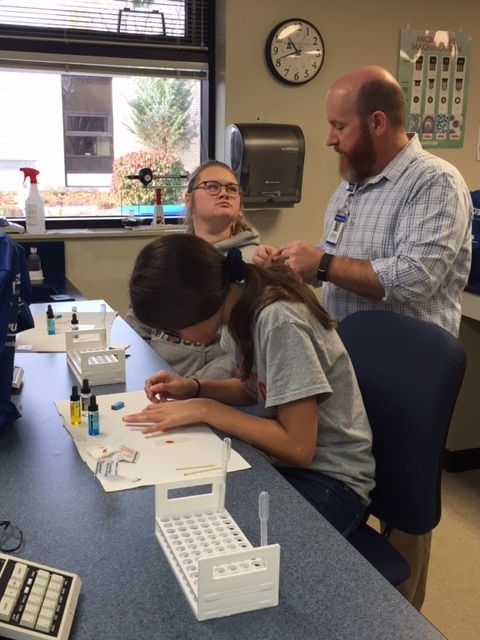 Dwane Klostermann helps students with blood typing