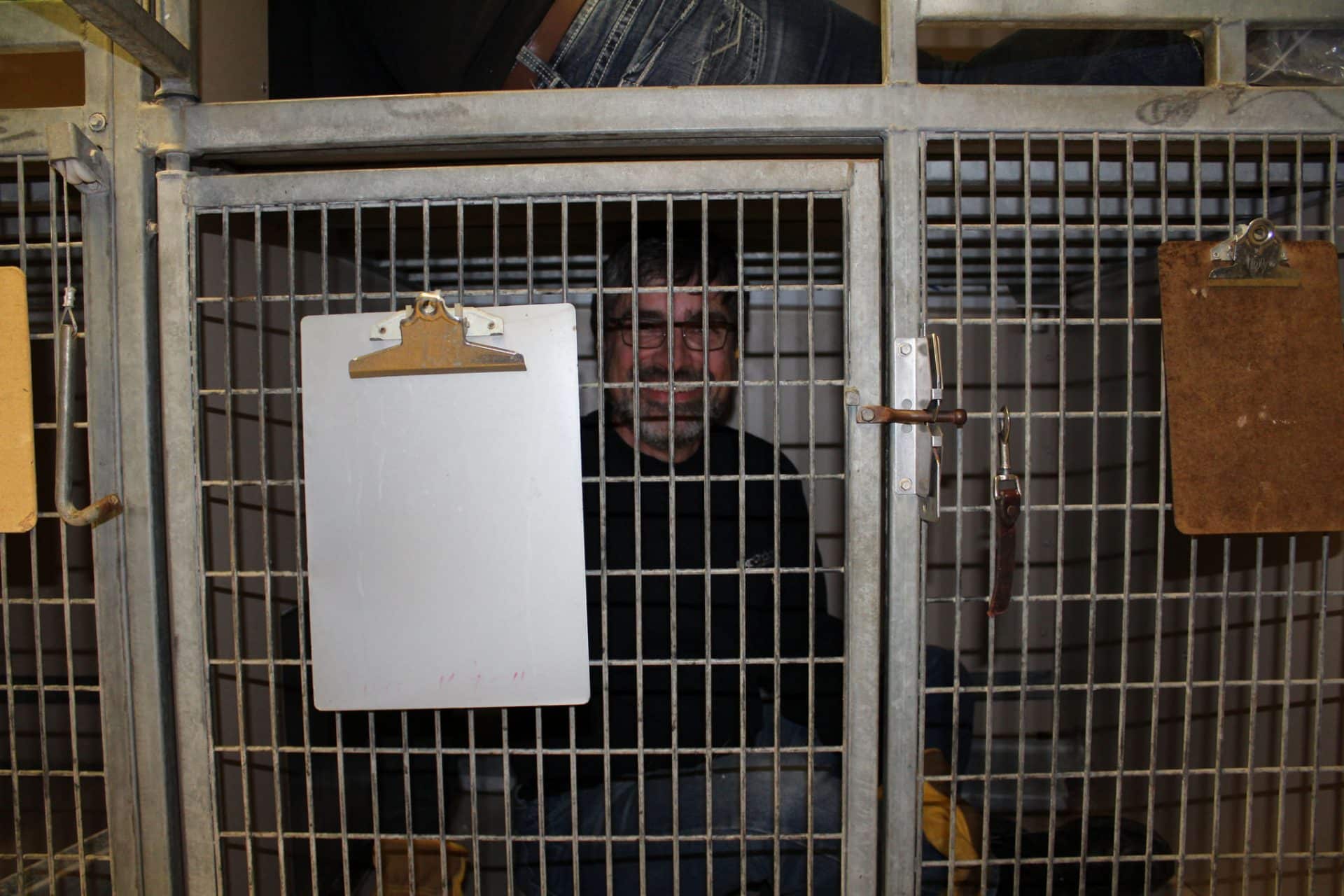 image of man sitting in kennel