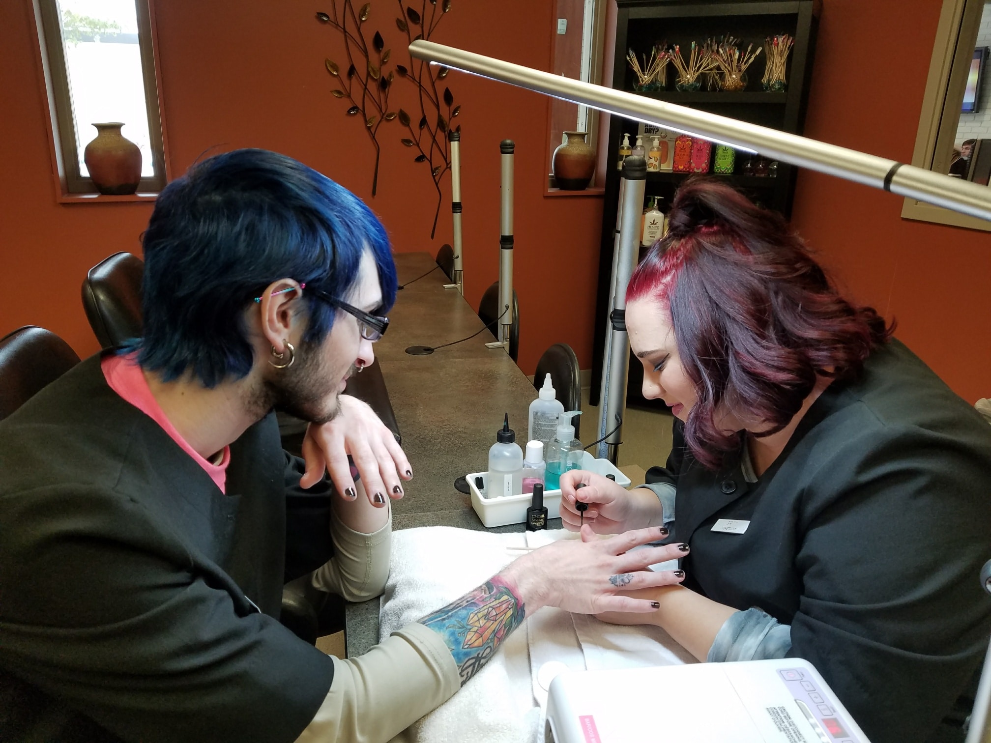 Cosmo student Britt giving Cosmo student Lex a manicure