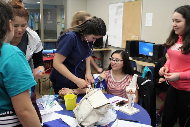 Moraine Park medical assistant student testing a young girls blood pressure. 