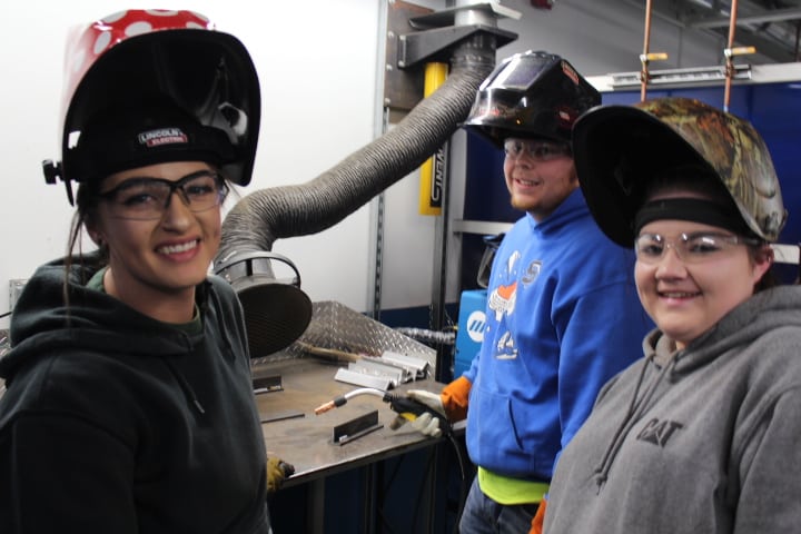Three welding students posing for a photo at Miller Electric.