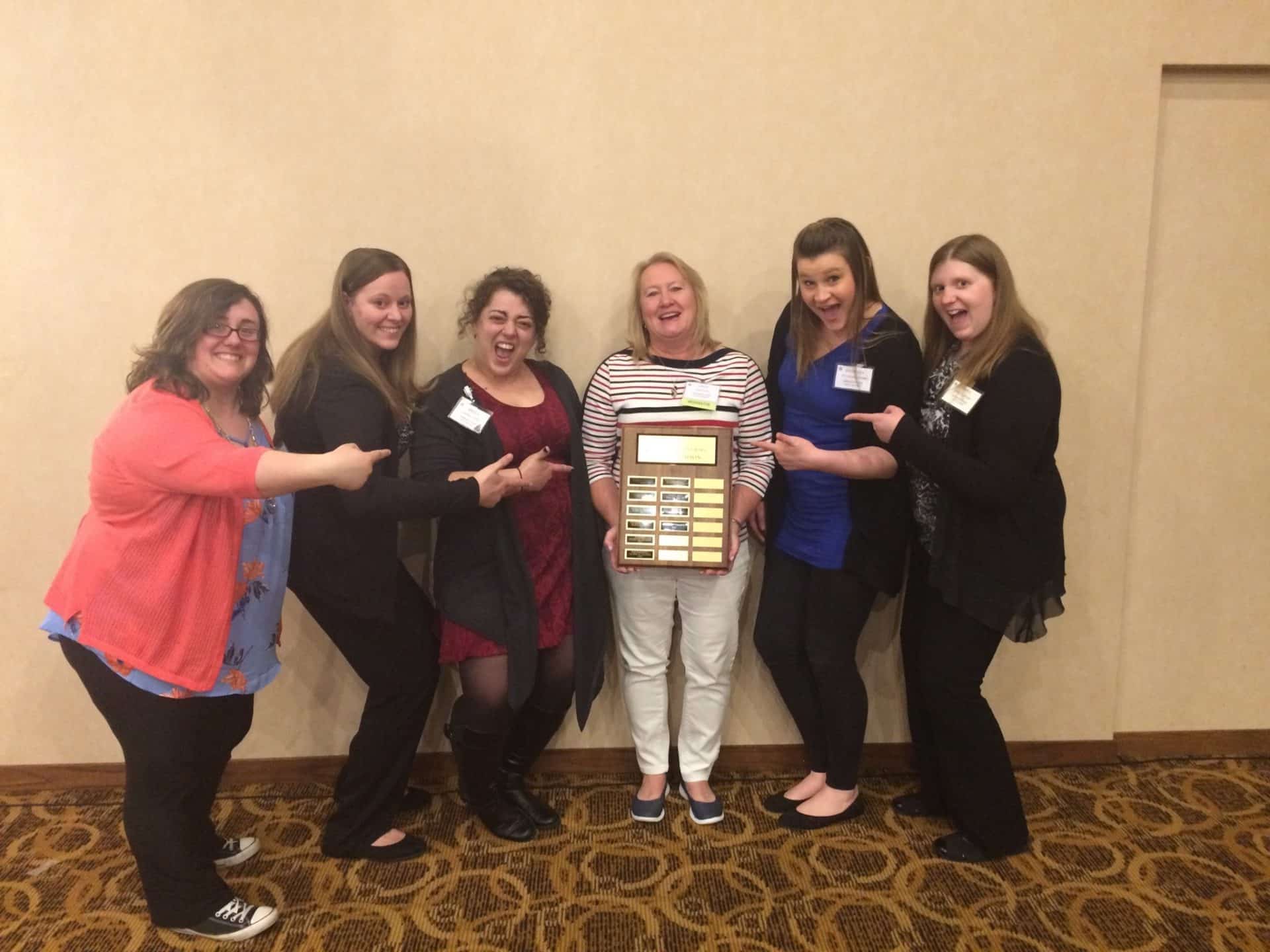 6 ladies holding a winning plaque