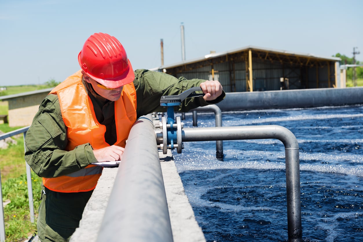 An engineer controlling the quality of water , aerated activated sludge tank at a waste water treatment plant .Copy space