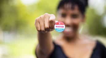 woman holding "i voted" sticker