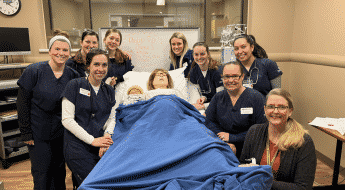 nursing students around birthing simulator